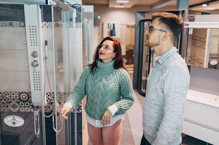 A couple inspects a shower unit in a store