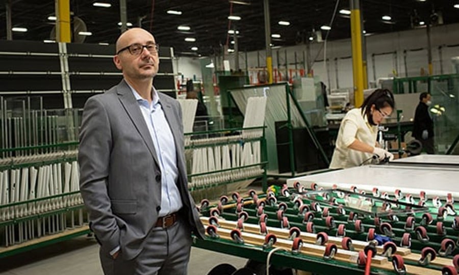 A well-dressed man stands before a machine