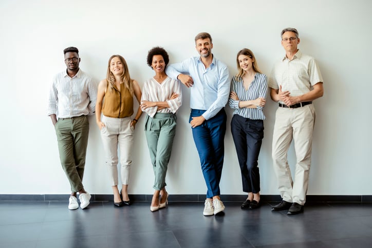 Group portrait of business people posing against office wall background